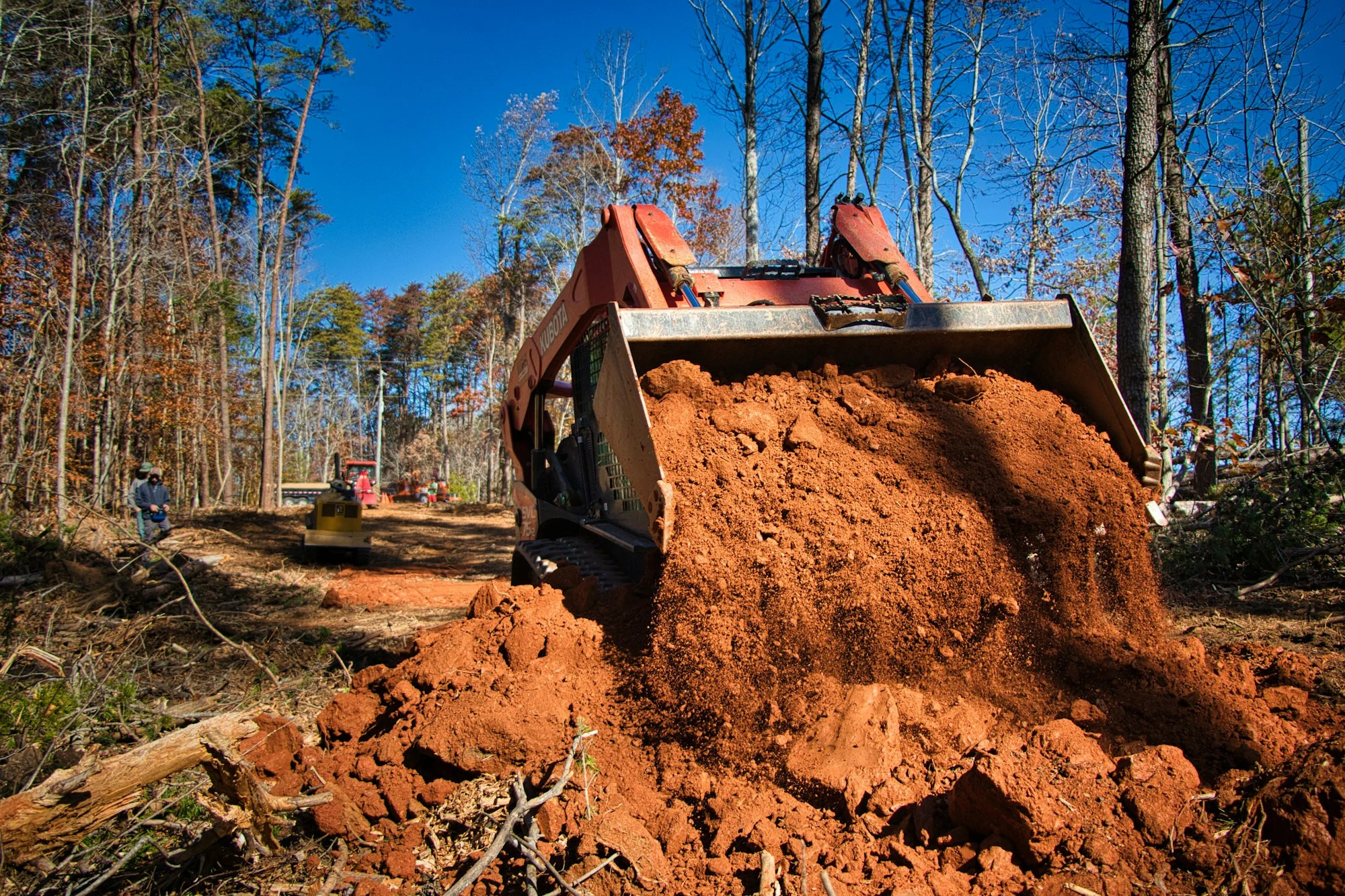 Skid steer preparing compacted fill for a concrete slab