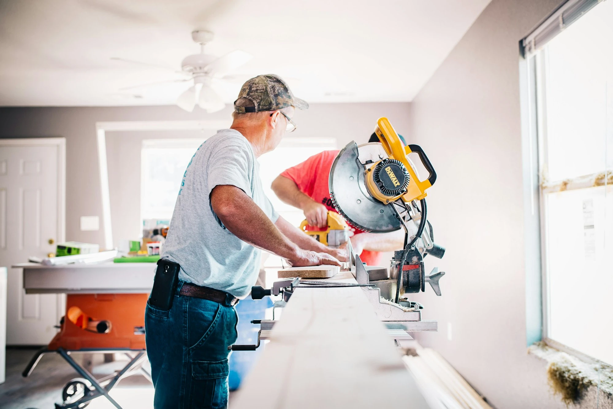 Carpenter cutting trim on a Polk County job site