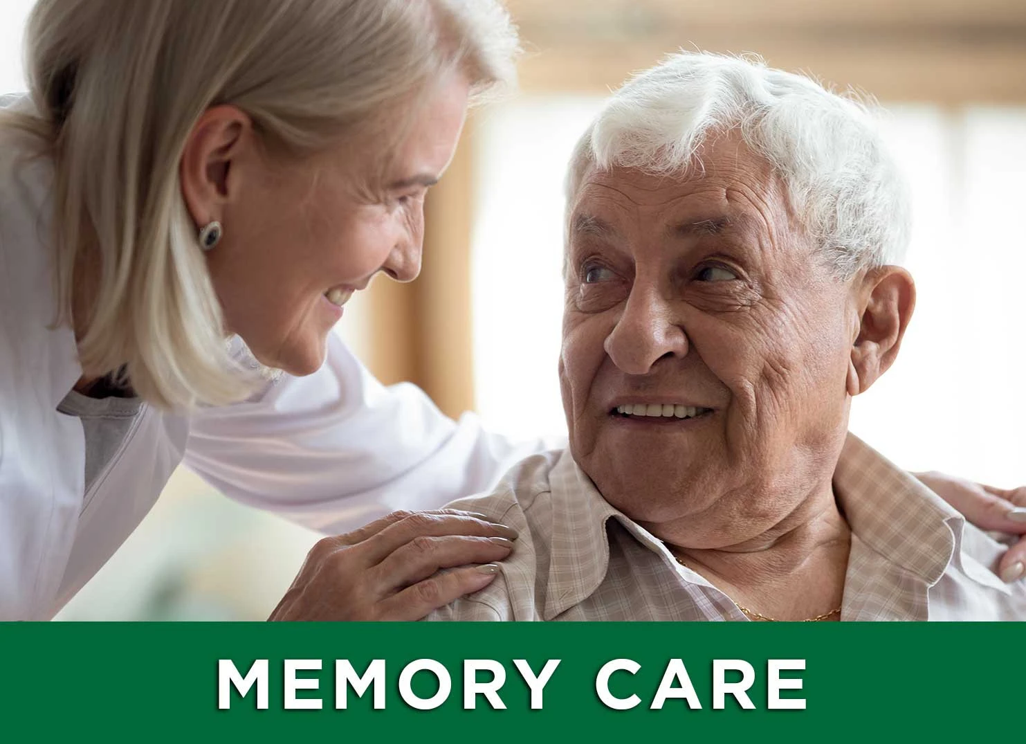 Image of senior male smiling up at caretaker with a link to the Memory Care page for more information