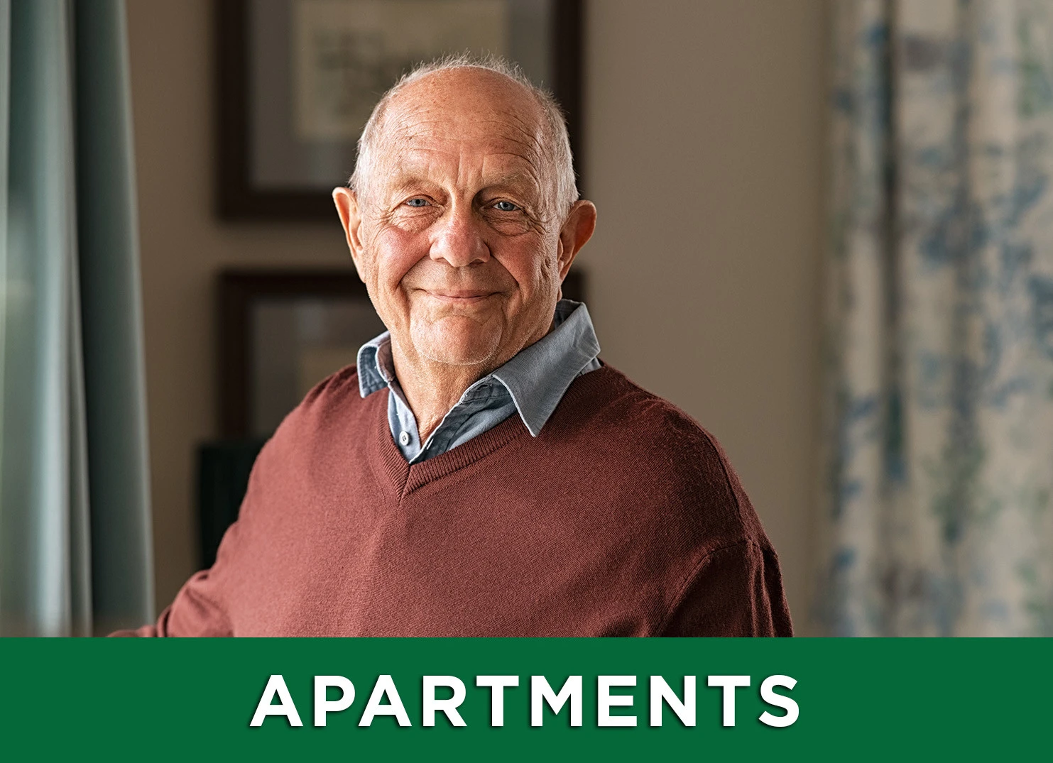 Image: Senior man smiling inside apartment with a link to the Apartments page