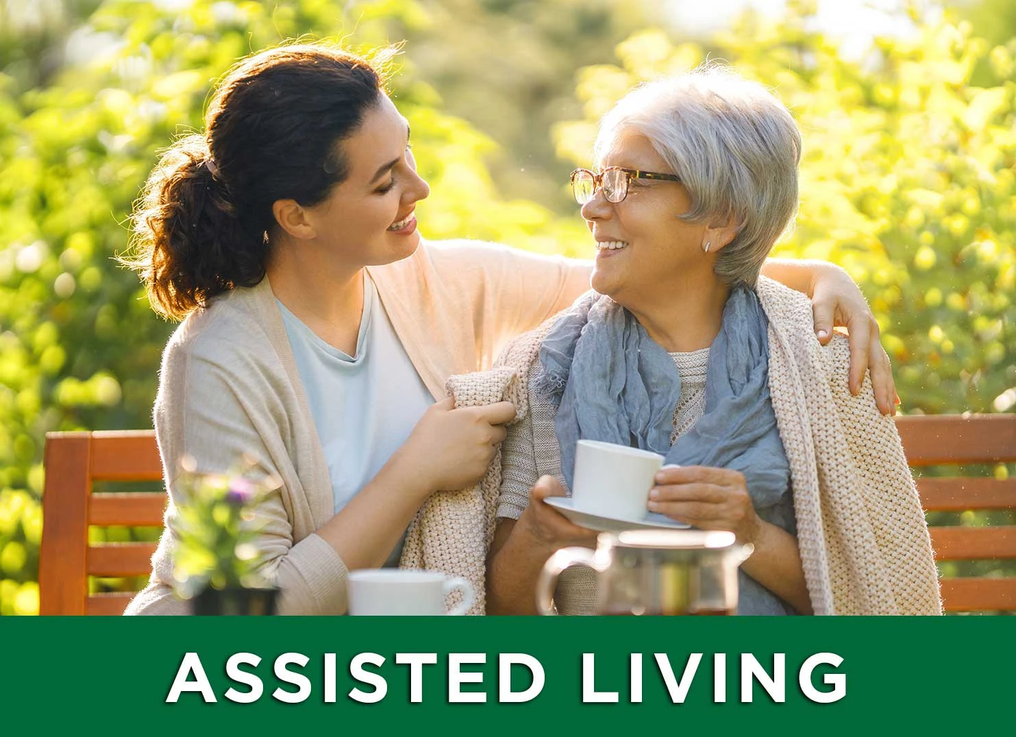 elderly woman and her daughter drinking tea on a park bench at an assisted living facility