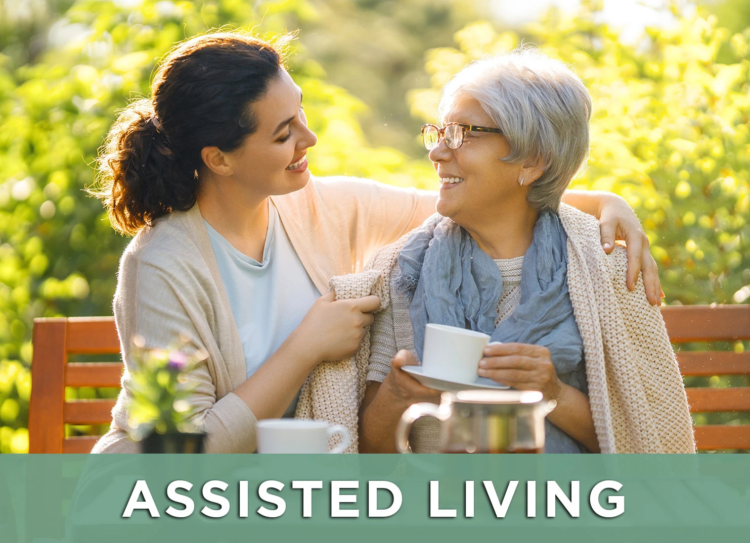 Image: happy senior woman smiling at caregiver on park bench and a link to the assisted living page to learn more