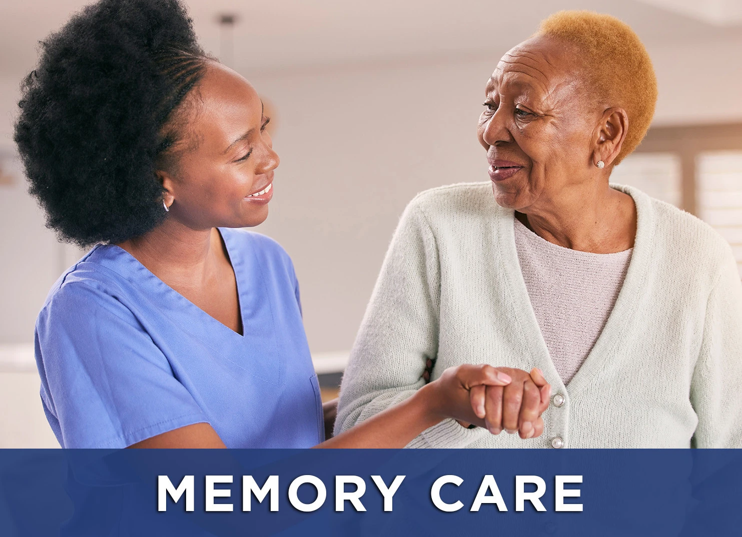Image of senior woman smiling at her caregiver with a link to the Memory Care page for more information