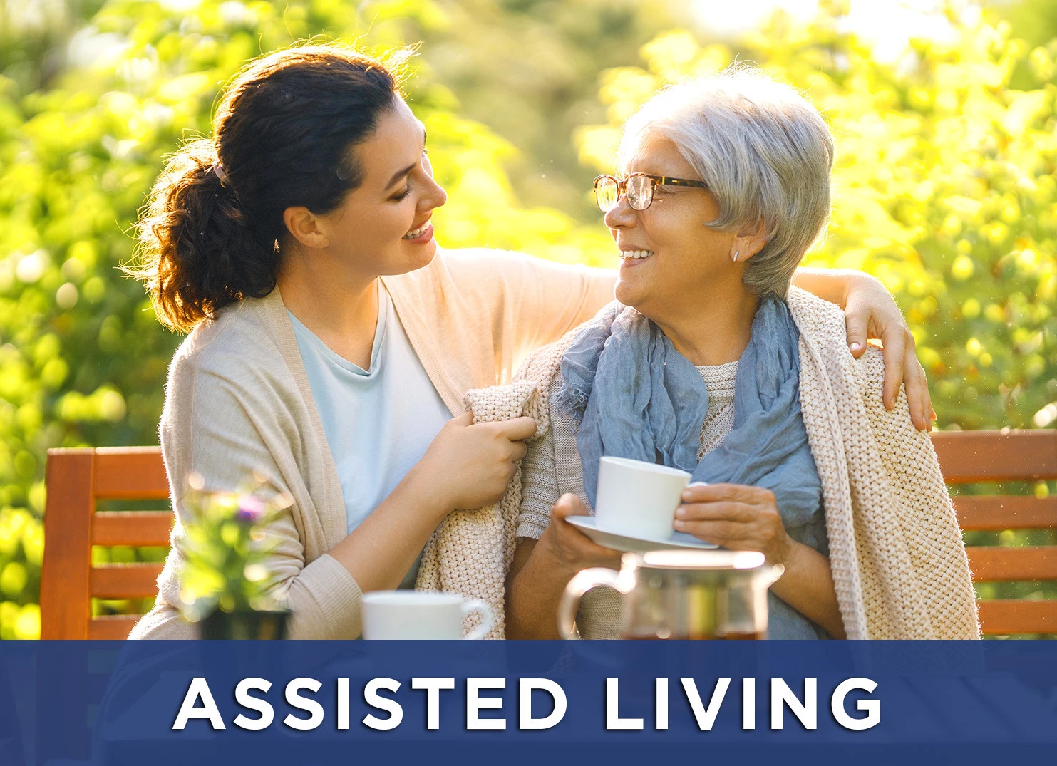 Image: elderly woman and her daughter drinking tea on a park bench at an assisted living facility with a link to learn more about assisted living