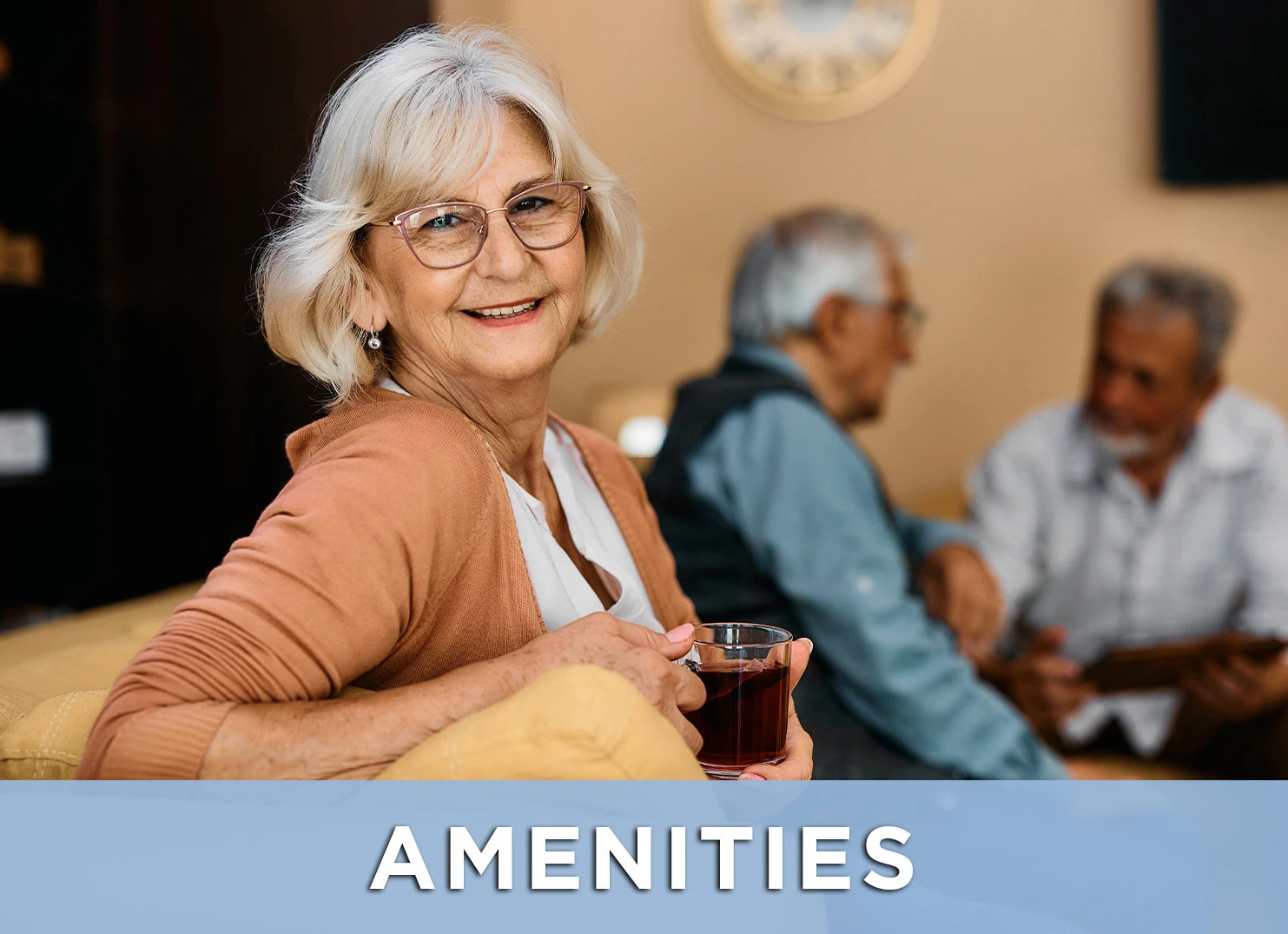 Image of senior woman enjoying a cup of coffee while two senior friends chat in the background with a like to the Amenities page for more information