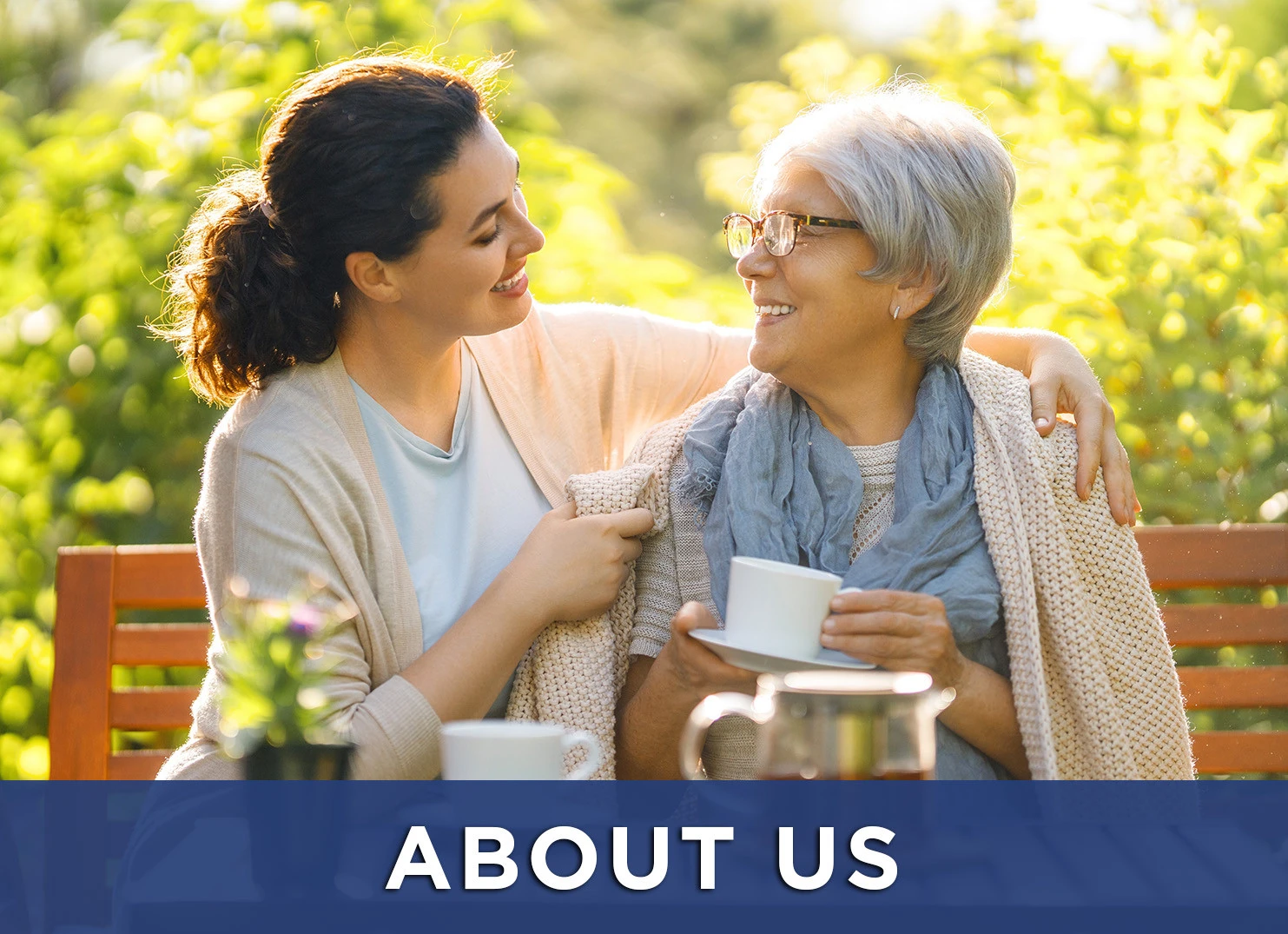 Image: senior woman and daughter on park bench with a link to the about us page
