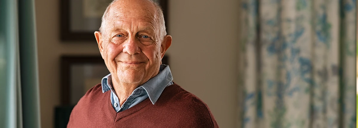 Elderly man proudly standing in his assisted living apartment