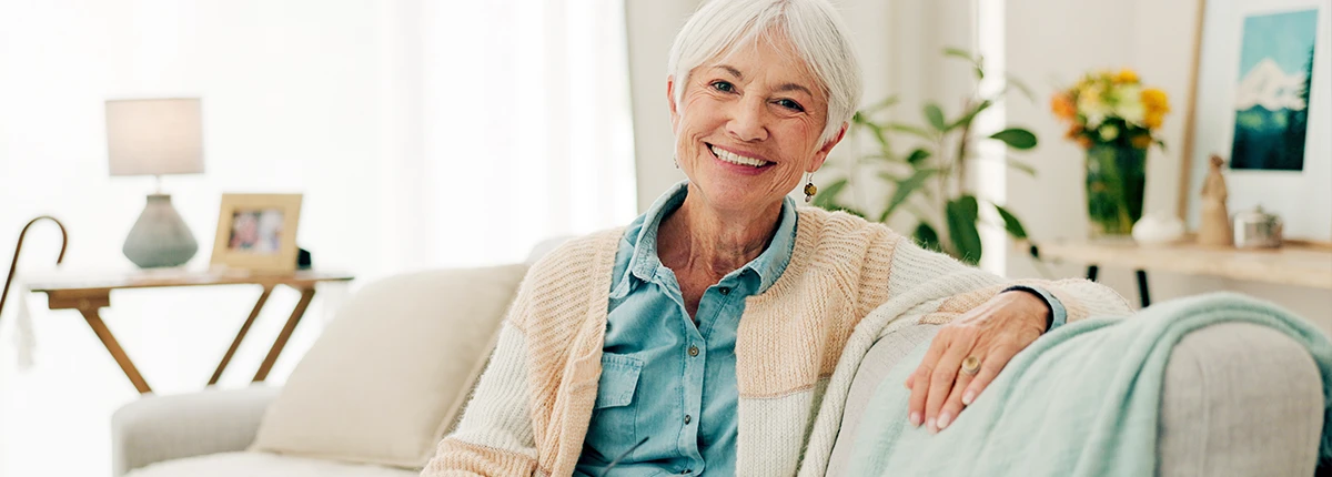 Group of senior friends enjoying breakfast and conversation at assisted living facility