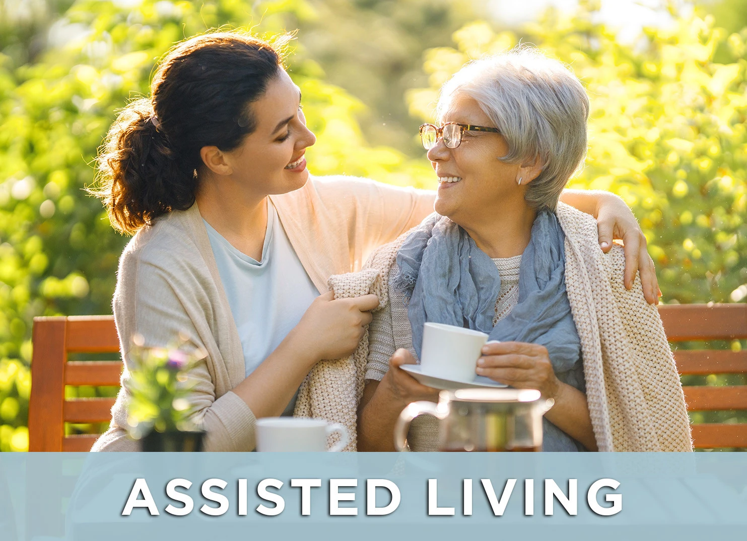 Image of senior woman and caregiver sitting on a park bench with a link to the Assisted Living page for more information