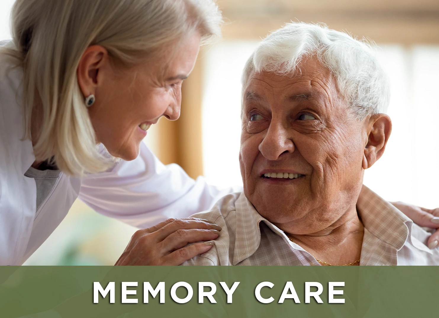 Image of older man smiling up at his caregiver with a link to the Memory Care page for more information