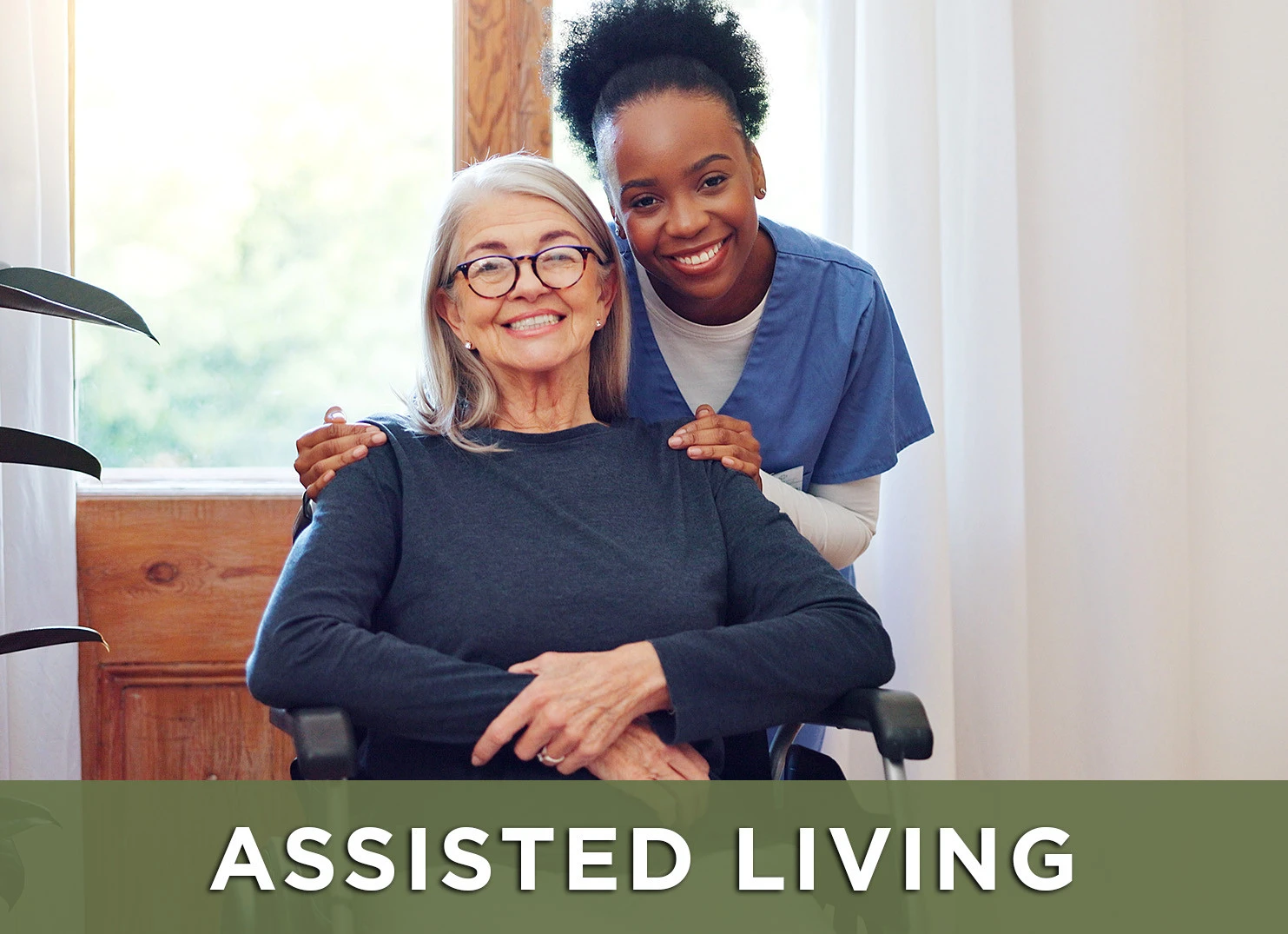 Image of senior woman in wheelchair smiling with a nurse with a link to the Assisted Living page for more information