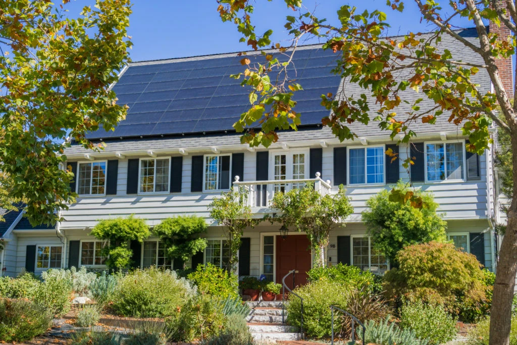House with solar panels on the roof in a residential neighborhood of Oakland, in San Francisco bay on a sunny day, California