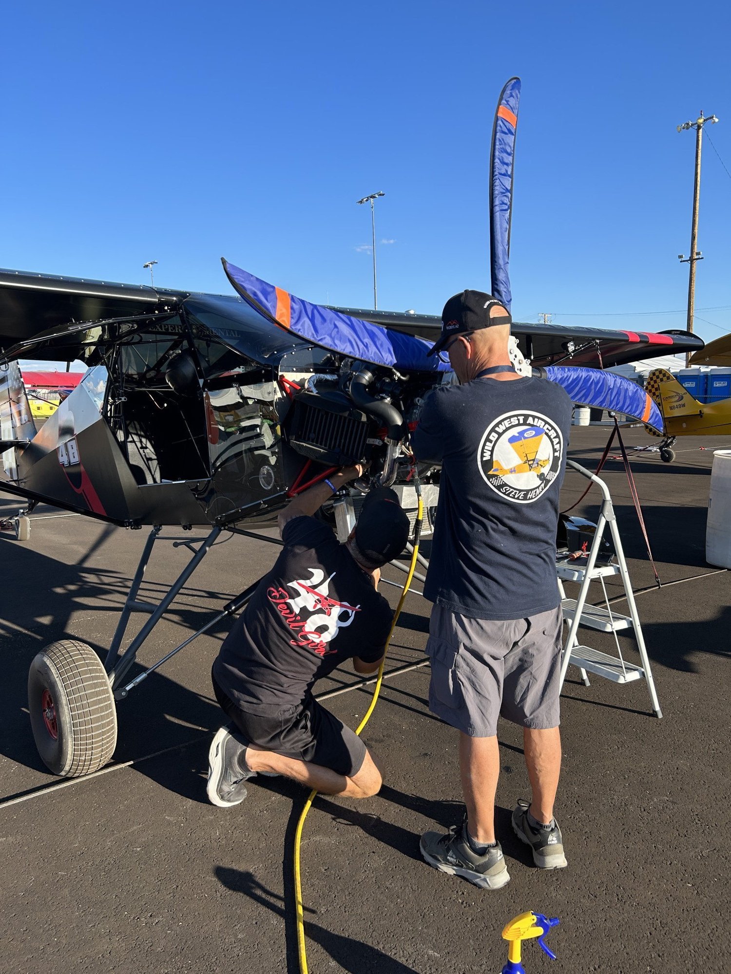 Steve Henry helps Eddie Sanches dial in his airplane for the first practice runs of the event.